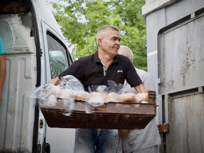En mann bærer en kurv med brød