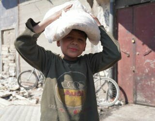 Syria, Aleppo. Barn står med foreldrene sine i køen, eller blir bedt om å hente brød alene før de går til skolen. Foto: WFP/ Hussam Al Saleh