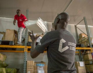 Logistikk-ansatte sjekker Personal Protective Equipment (PPE) som blir lastet ut av et temperaturregulert varehus i Lologo, Juba. Foto: WFP/Giulio d'Adamo