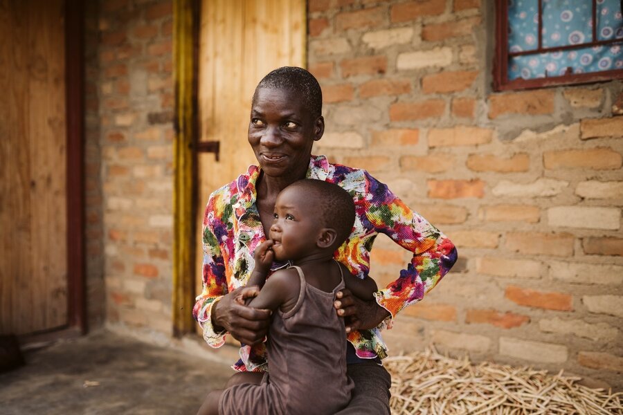 Farmer Shupikai, here with a grandchild, has benefitted from WFP early action initiatives to cope with drought. Photo: WFP/Maria Gallar